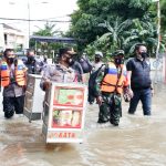 Kapolsek Kembangan Panggul Gerobak Roti Arungi Banjir Demi Warga Terdampak Banjir