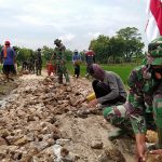 Bersama Dinas PU Cipta Karya, Satgas TMMD Kodim Bojonegoro Dan Warga Pasang Batu Dasar Pembangunan Jalan