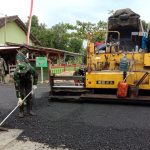 Tak Kenal Cuaca, Serda Edi Ratakan Aspal Pembangunan Jalan TMMD Bojonegoro