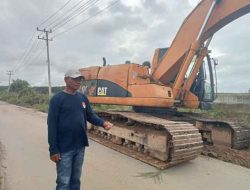 Menggunakan Alat Berat Ekskavator, Kakam Warga Indah Jaya Bersihkan Semak Belukar Di Sepanjang Jalan Kampung